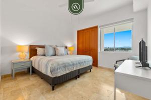 a bedroom with a bed and a desk and a tv at Stylish 2 BR Condo - Pools - Golf - Membership in Jarretadera +33 photos