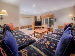 Una sala de estar con dos camas y un televisor. en RMR: Snow Ridge 4 Condo in Teton Village, en Teton Village