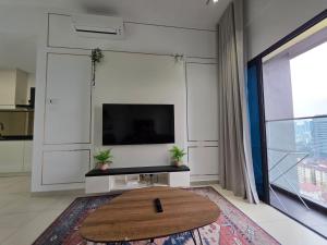 a living room with a tv and a coffee table at Reizz Residence by Perkasa Suites in Batu Empat