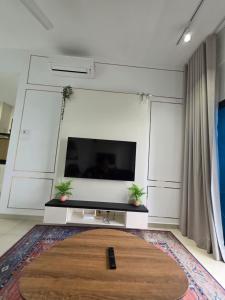 a living room with a flat screen tv and a rug at Reizz Residence by Perkasa Suites in Batu Empat +20 photos