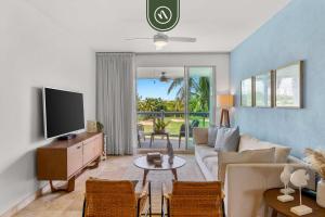 a living room with a couch and a tv at Stylish 2 BR Condo - Pools - Golf - Membership in Jarretadera