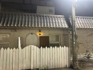 una cerca blanca frente a una casa en The best hot spring room in town, en Hengchun