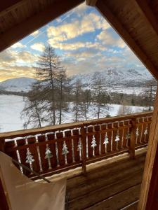 a window in a cabin with a view of snow covered mountains at Chalet Cosy in La Joue du Loup