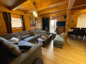 a living room with a couch and a table at Chalet Cosy in La Joue du Loup