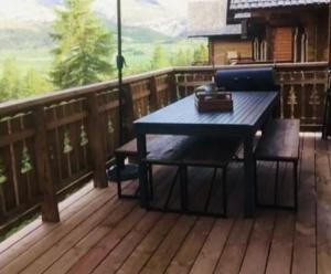 a blue table and chairs on a wooden deck at Chalet Cosy in La Joue du Loup