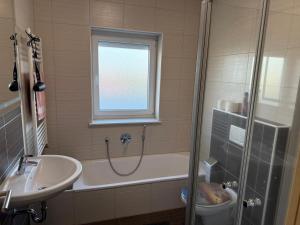 a bathroom with a tub and a sink and a shower at Penthouse Appartment in Paderborn +4 photos