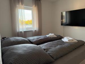 two beds sitting in a room with a window at Penthouse Appartment in Paderborn