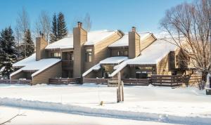 a house covered in snow in the snow at RMR: Cinquefoil 1613 Condo in The AspensWilsonWY in Wilson