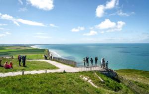 un groupe de personnes debout sur une falaise surplombant l'océan dans l'établissement 3 Bedroom Awesome Home In Zutkerque, à Zutkerque