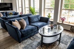 a living room with a blue couch and a glass table at Hotel Stensson in Eslöv