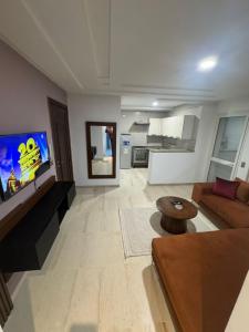 a living room with a couch and a flat screen tv at Résidence les jasmins l''aouina in Tunis