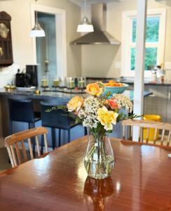 a vase of flowers sitting on a wooden table at Clementine Cottage in Citrusdal