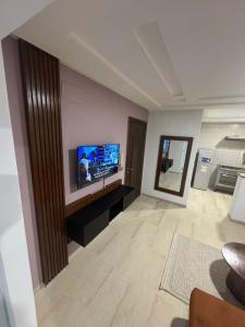 a living room with a flat screen tv on a wall at Résidence les jasmins l''aouina in Tunis +3 photos