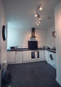 a kitchen with a washing machine and a washer at Bluetree Apartments Guild Street City Center in Aberdeen