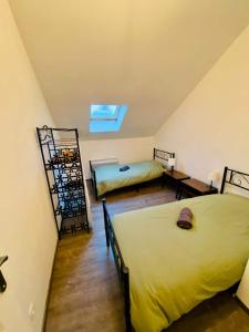 a attic bedroom with two beds and a window at Business Apparts Caudry in Caudry
