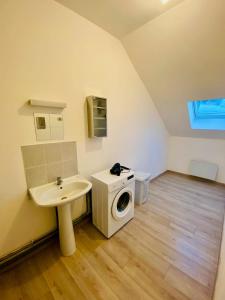 a bathroom with a washing machine and a sink at Business Apparts Caudry in Caudry