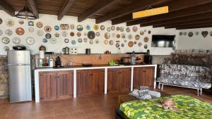 a kitchen with a refrigerator and a table with a child on a bed at Loft Tortuga in Tinajo