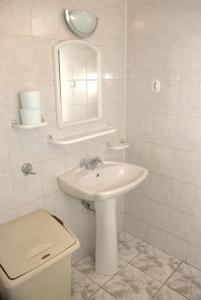 Un baño con lavabo, inodoro y espejo. en Oliwier, en Rewal