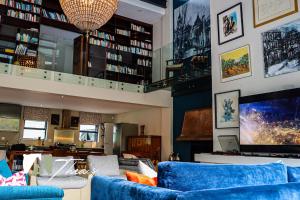 a living room with blue couches and a tv at The Bishops Villa in Cape Town