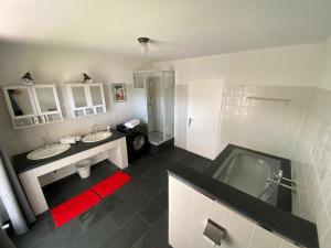 a bathroom with two sinks and a bath tub at Café Pension Pfaus Heidburg in Mühlenbach +73 photos