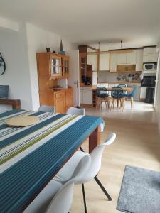 a kitchen and living room with a table and chairs at Maison de la fontaine in Saint-Méloir-des-Ondes