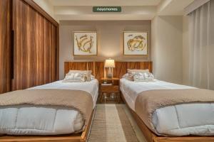 twee bedden in een hotelkamer met bij Luxury 2BR Condo in Nuevo Vallarta - Rooftop Pool in Nuevo Vallarta  +32 foto's