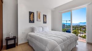 een witte slaapkamer met een groot bed en een groot raam bij Equipped 3BR House - Pool - Gym - 5 min to Beach in Nuevo Vallarta  +76 foto's