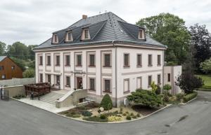 a large white house with a black roof at Hotel Zámeček Raspenava in Raspenava