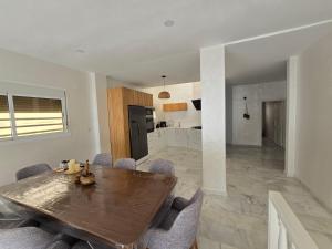 a kitchen and dining room with a wooden table and chairs at Zaouch house in Moulay Bousselham