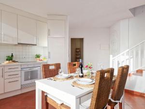 a white kitchen with a white table and chairs at Seaside Home Jacuzzi Pool Free Surf Retreat in El Médano