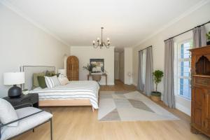 una camera da letto bianca con un letto e un divano di Bloom Garden Cottage a Constantia