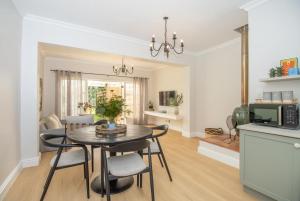 una cucina e un soggiorno con tavolo e sedie di Bloom Garden Cottage a Constantia