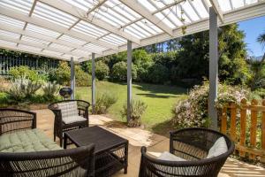 patio con sedie e tavolo sotto un pergolato bianco di Bloom Garden Cottage a Constantia Altre 4 foto