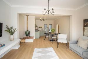 un soggiorno con un divano e un tavolo di Bloom Garden Cottage a Constantia