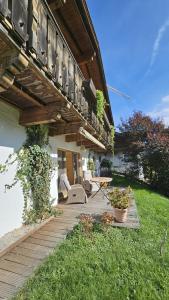 a porch with a wooden deck with a table and chairs at Almrose Zauber by Alpenchalet Almrose in Oberau