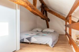 a bed in a room with wooden beams at Le cocon - Appartement en hyper centre in Blois +1 photo