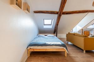 a bedroom with a bed and a couch at Le cocon - Appartement en hyper centre in Blois