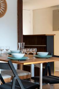 a wooden table with bowls and glasses on it at Le cocon - Appartement en hyper centre in Blois