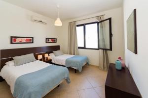 una camera d'albergo con due letti e una finestra di Villa Nayra a Playa Blanca Altre 15 foto