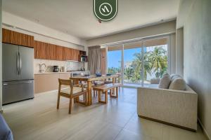 a kitchen and living room with a table and a couch at New 1 BR Condo with Amazing Rooftop Pool - Jacuzzi in Bucerías