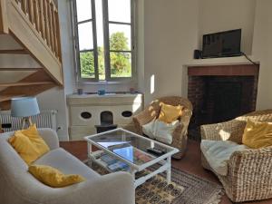 a living room with two chairs and a fireplace at Les Gîtes du chateau de Craon in Craon