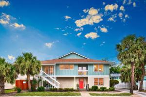 a house with palm trees in front of it at The Big Tybreezy in Tybee Island