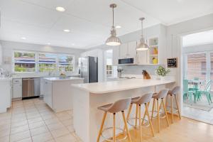 a kitchen with a large white island with bar stools at The Big Tybreezy in Tybee Island