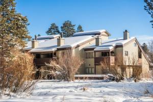 une maison dans la neige avec de la neige dans l'établissement RMR: Geranium 2621 Condo in The AspensWilsonWY, à Wilson
