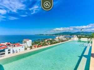 a pool on the roof of a building with a view of the ocean at New 1 BR Condo with Amazing Rooftop Pool - Jacuzzi in Bucerías