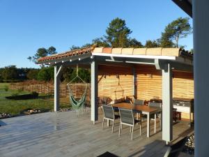 a wooden deck with a pavilion with a table and chairs at Villa nature in Léon