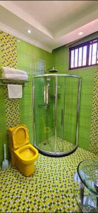 a bathroom with a shower and a yellow toilet at Premium Residence in Maputo