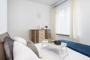 - un salon blanc avec un lit et une table dans l'établissement Elite Apartments Basilica Mariacka, à Gdańsk