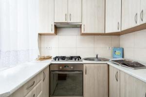 une cuisine avec une cuisinière et un évier dans l'établissement Elite Apartments Basilica Mariacka, à Gdańsk