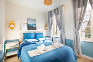 a blue bed in a bedroom with two towels at Le Green Escape in Sélestat